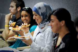 Students chat over pizza at the event.