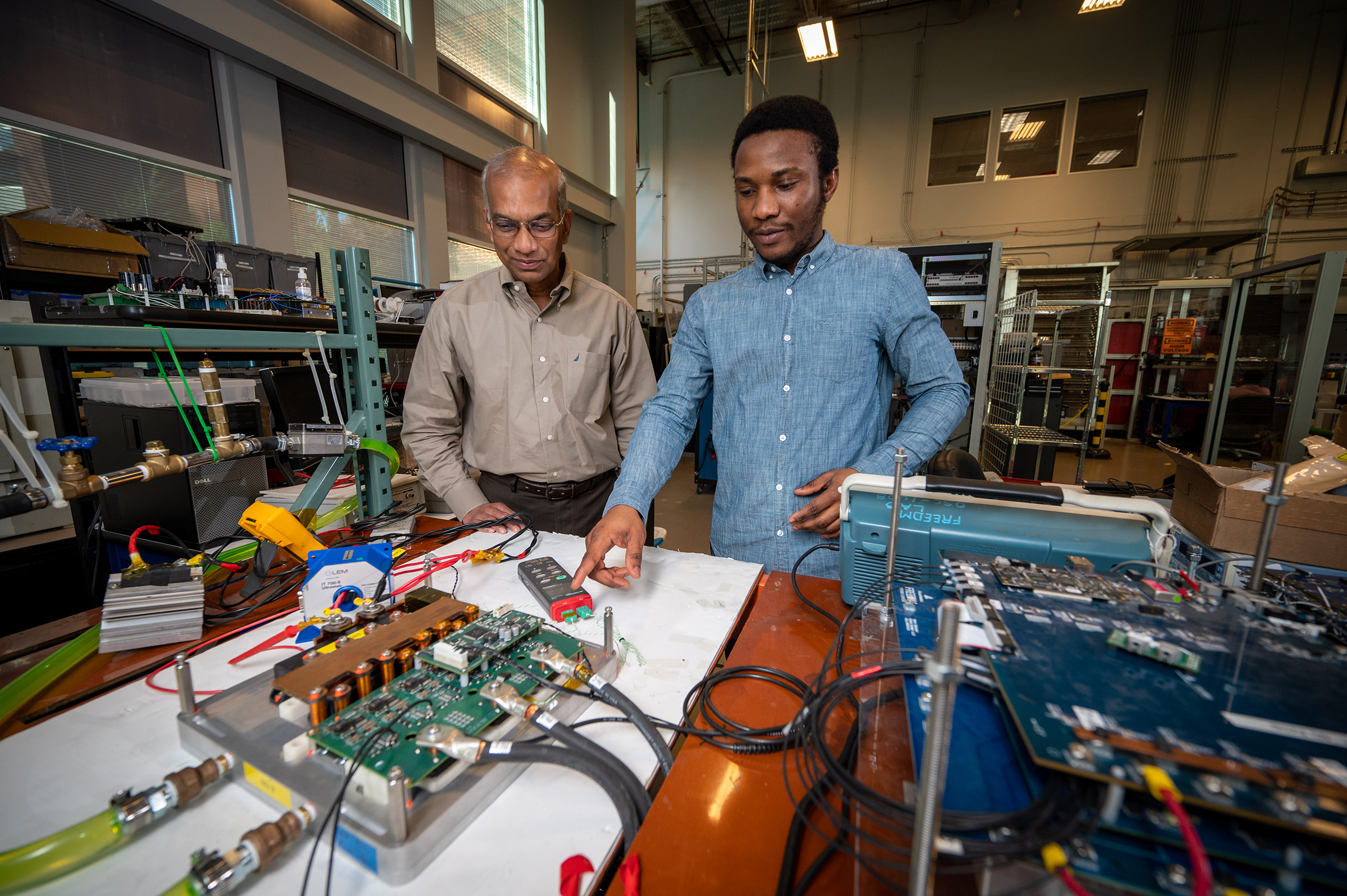 Iqbal Husain works with a graduate student inside of the FREEDM Center on Centennial campus.