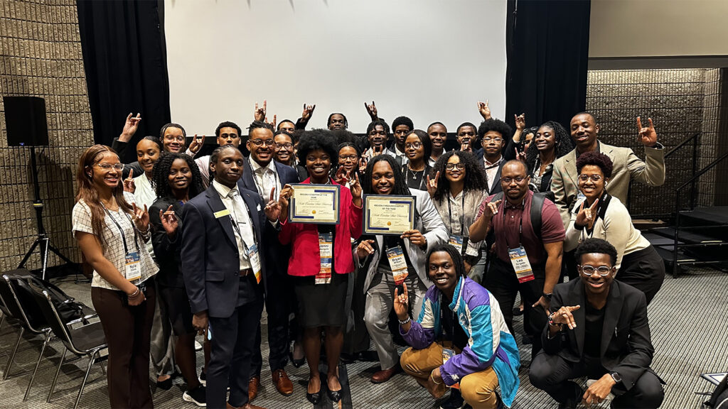 The NC State NSBE chapter pose after winning two awards. Jenni Mangala, center left, and Bryan Washington, center right, hold the awards.