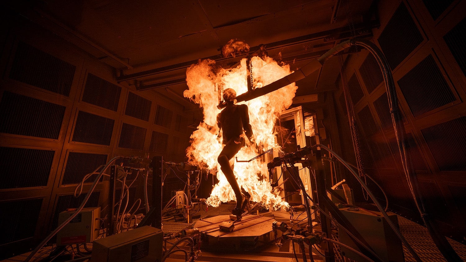 Inside a testing lab, a human-sized manikin moves inside flames.