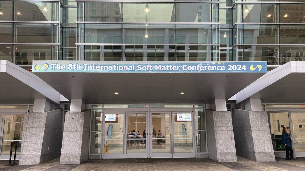 Photo from the International Soft Matter Conference 2024 showing large banner at entrance to the Raleigh Convention Center.