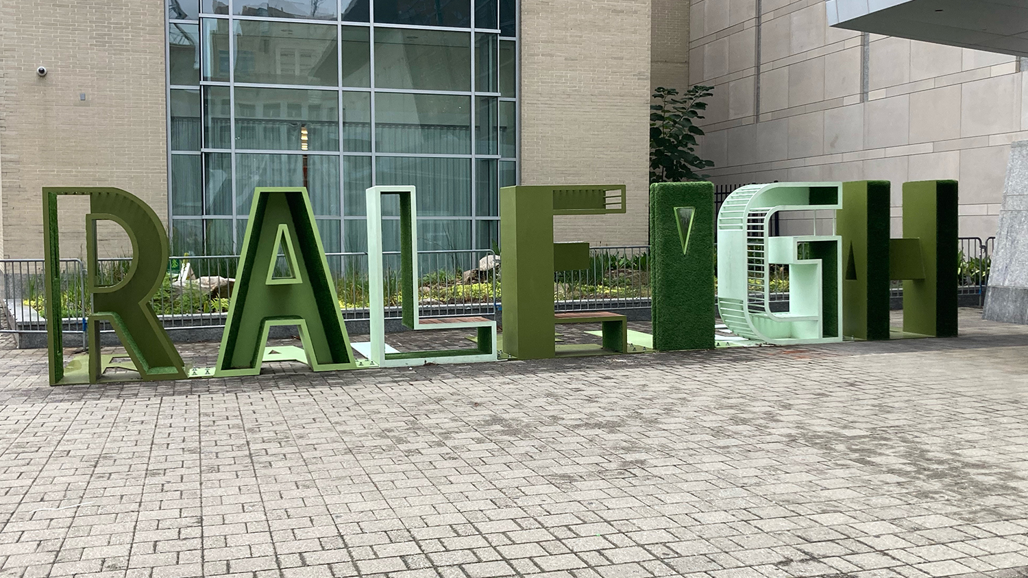 Large, green metal letters spell RALEIGH at the Raleigh Convention Center.