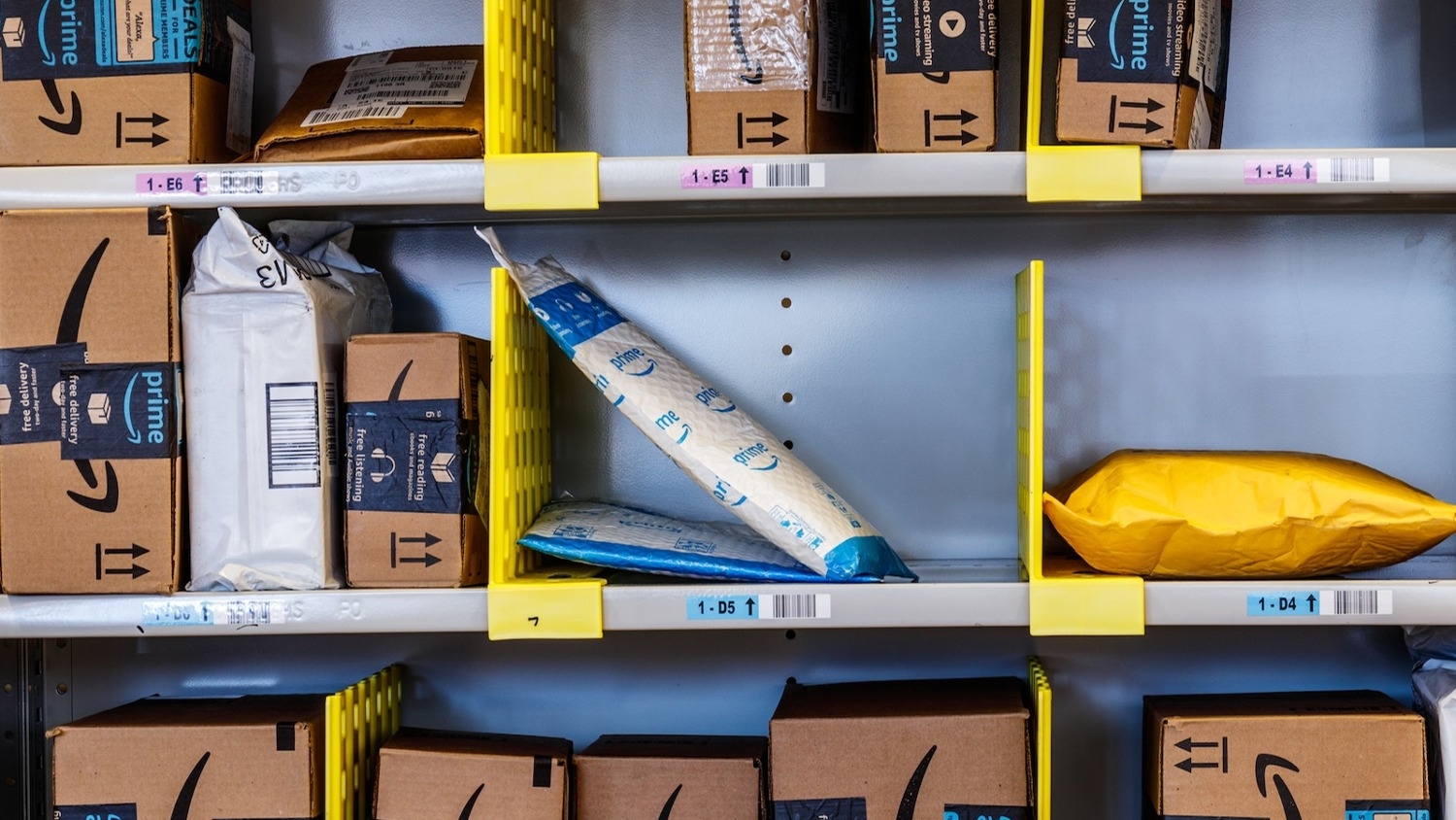 Amazon packages stacked on shelves.