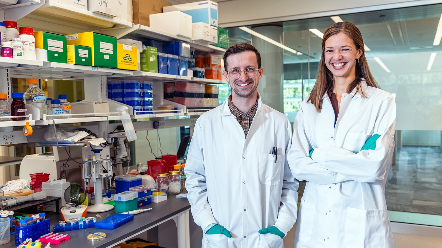 Scott Collins and Kathryn Poloff of Hoofprint Biome pose smiling in their lab coats.