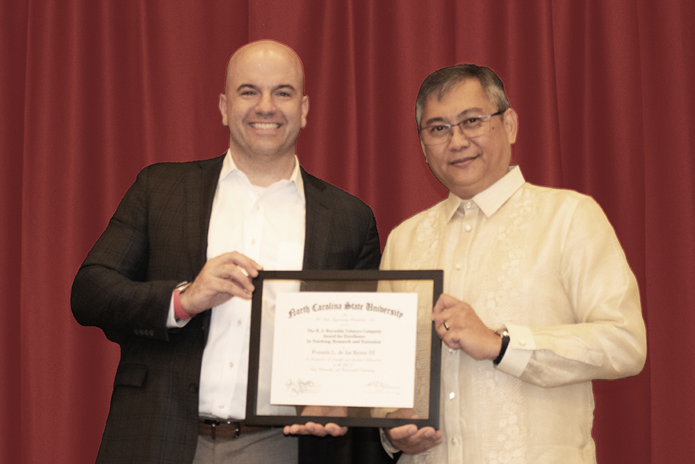 Dean Jim Pfaendtner, left, presents Francis de los Reyes with the 2024 RJ Reynolds Award.