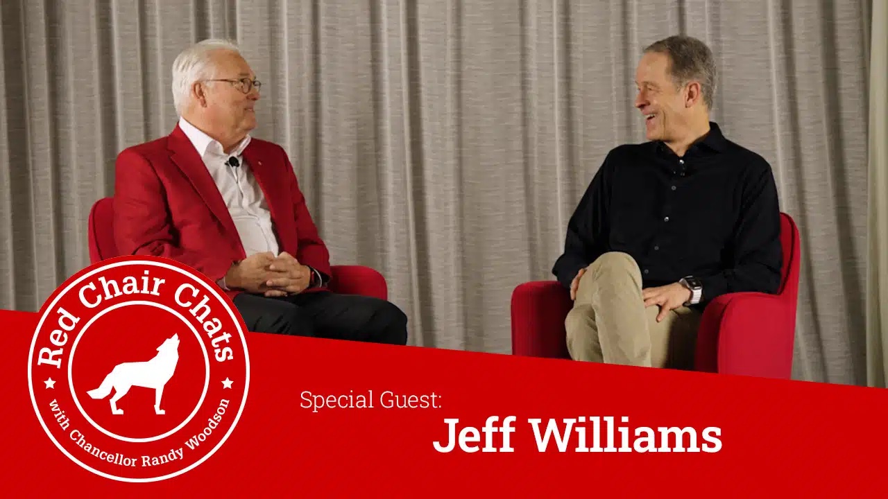 Chancellor Woodson and Jeff Williams sit on stage in red chairs. A graphic with the Red Chair Chats logo says "Red Chair Chats with Chancellor Woodson, Special Guest Jeff Williams