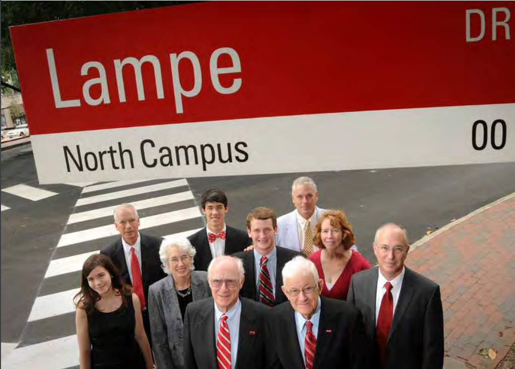 A group of NC State alumni from the Lampe family stand below the Lampe Drive street sign on NC State's main campus in 2010.