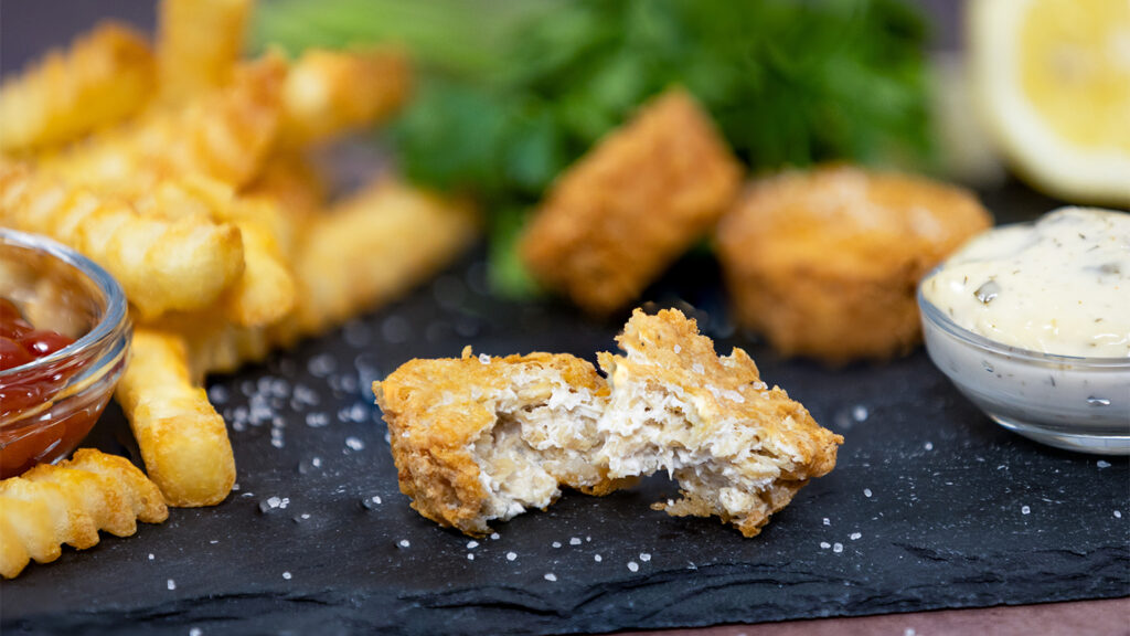 A hybrid fish nugget with fries and tartar sauce.