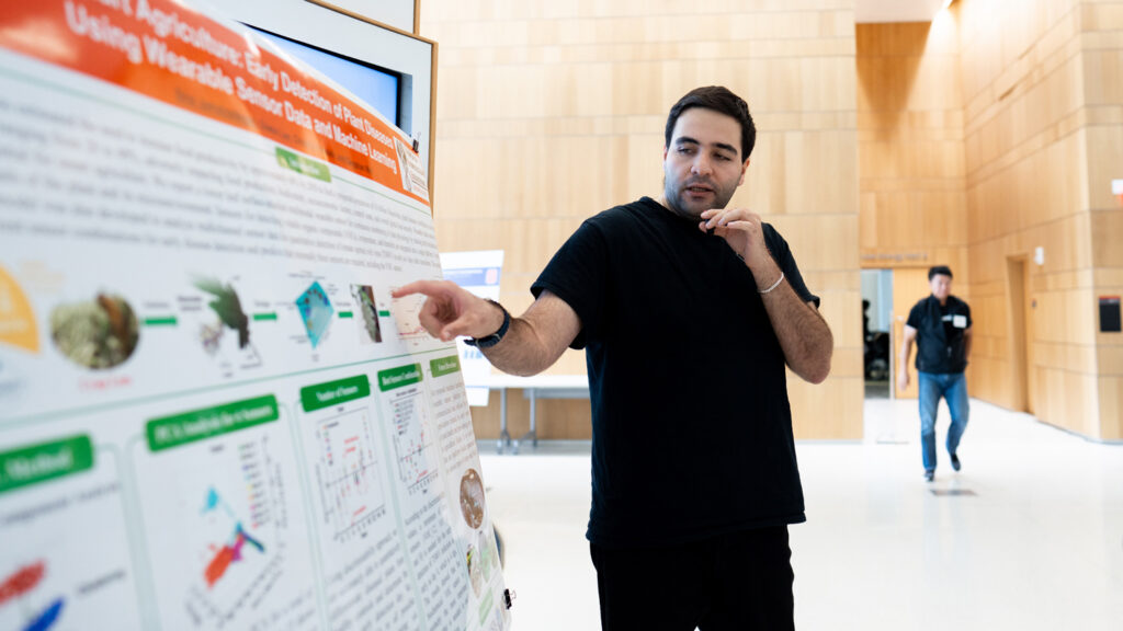 Graduate student conducts a poster presentation during the first AI Symposium at the College of Engineering at NC State University.