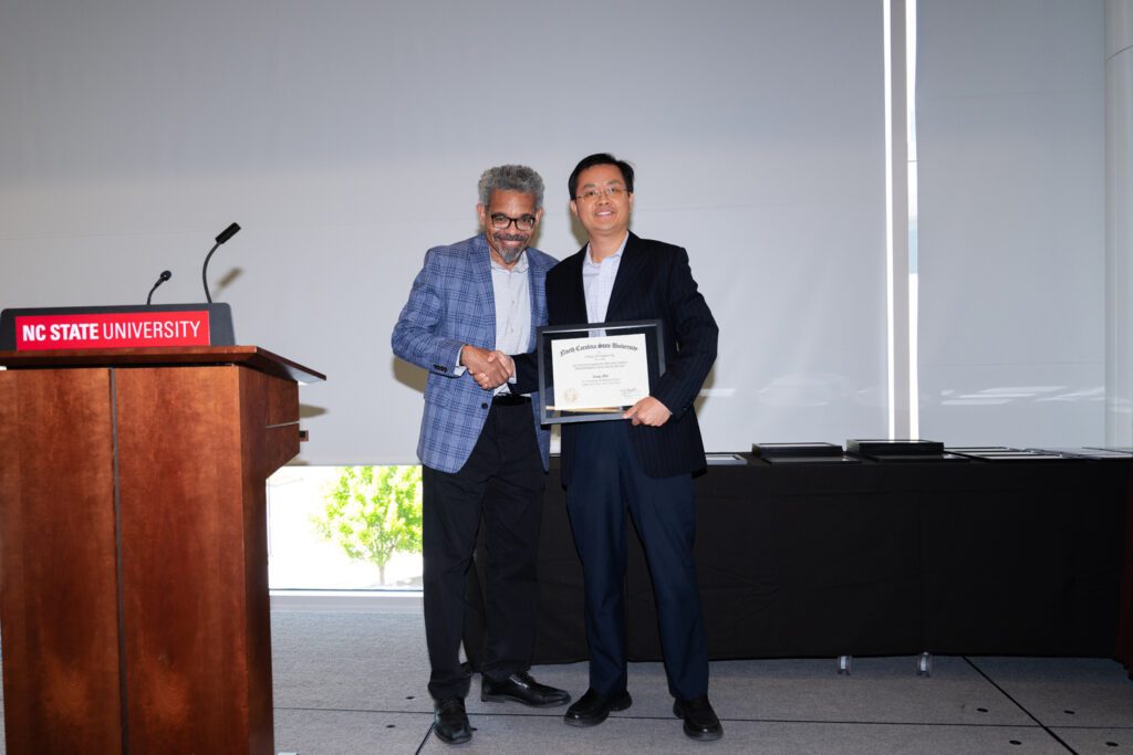 Yong Zhu, right, receives award from Joel Ducoste.