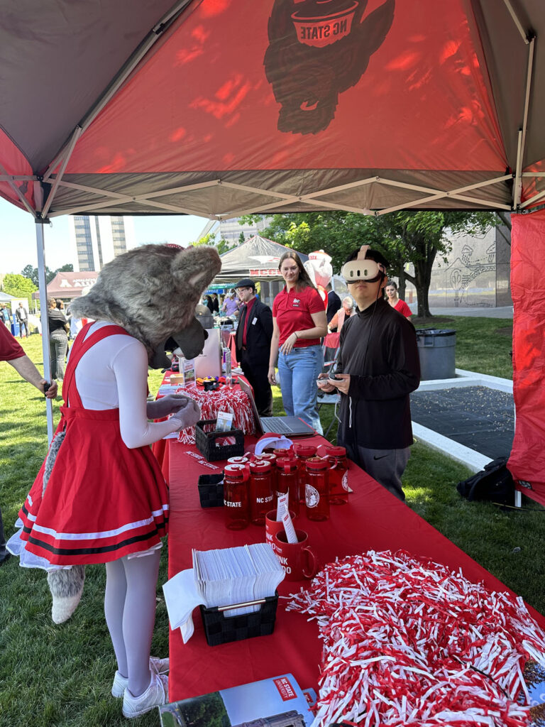 Ms. Wuf at a red display table under a red canopy