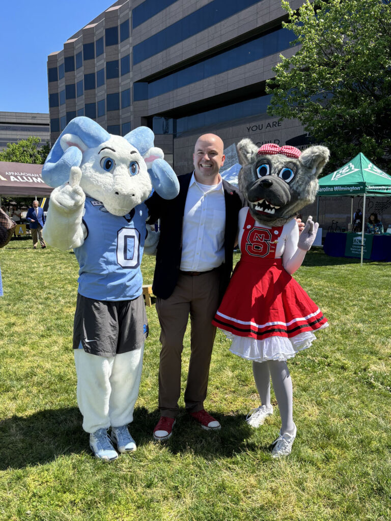 Dean Jim Pfaendtner poses with UNC and NC State mascots.