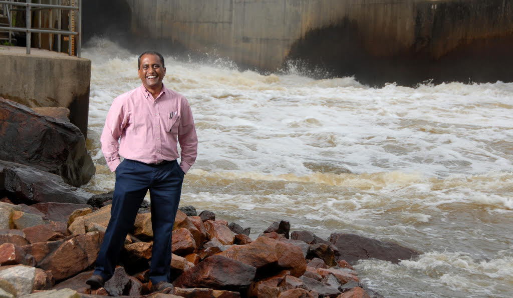 Sankar Arumugam stands on rocks next to the spillway at Falls Lake in Raleigh, NC.