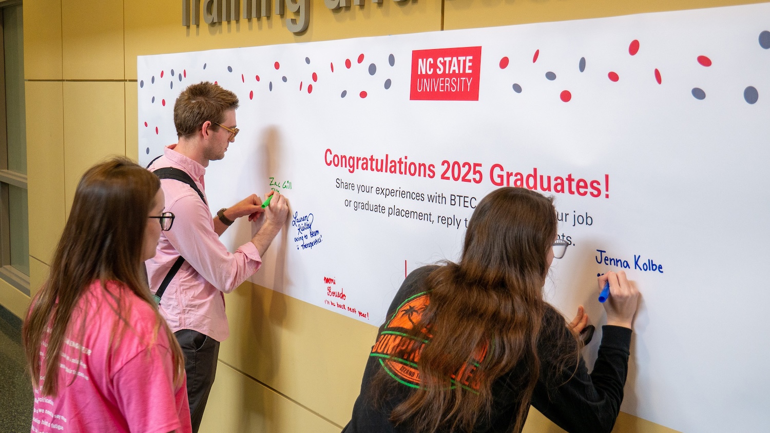Students signing a banner and sharing their plans for the future.