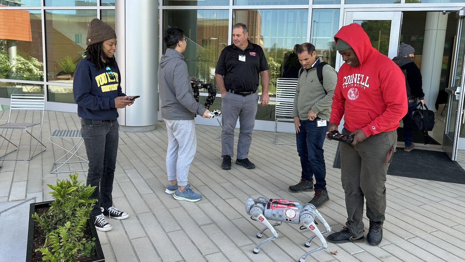 Group looking at a small, dog-like robot