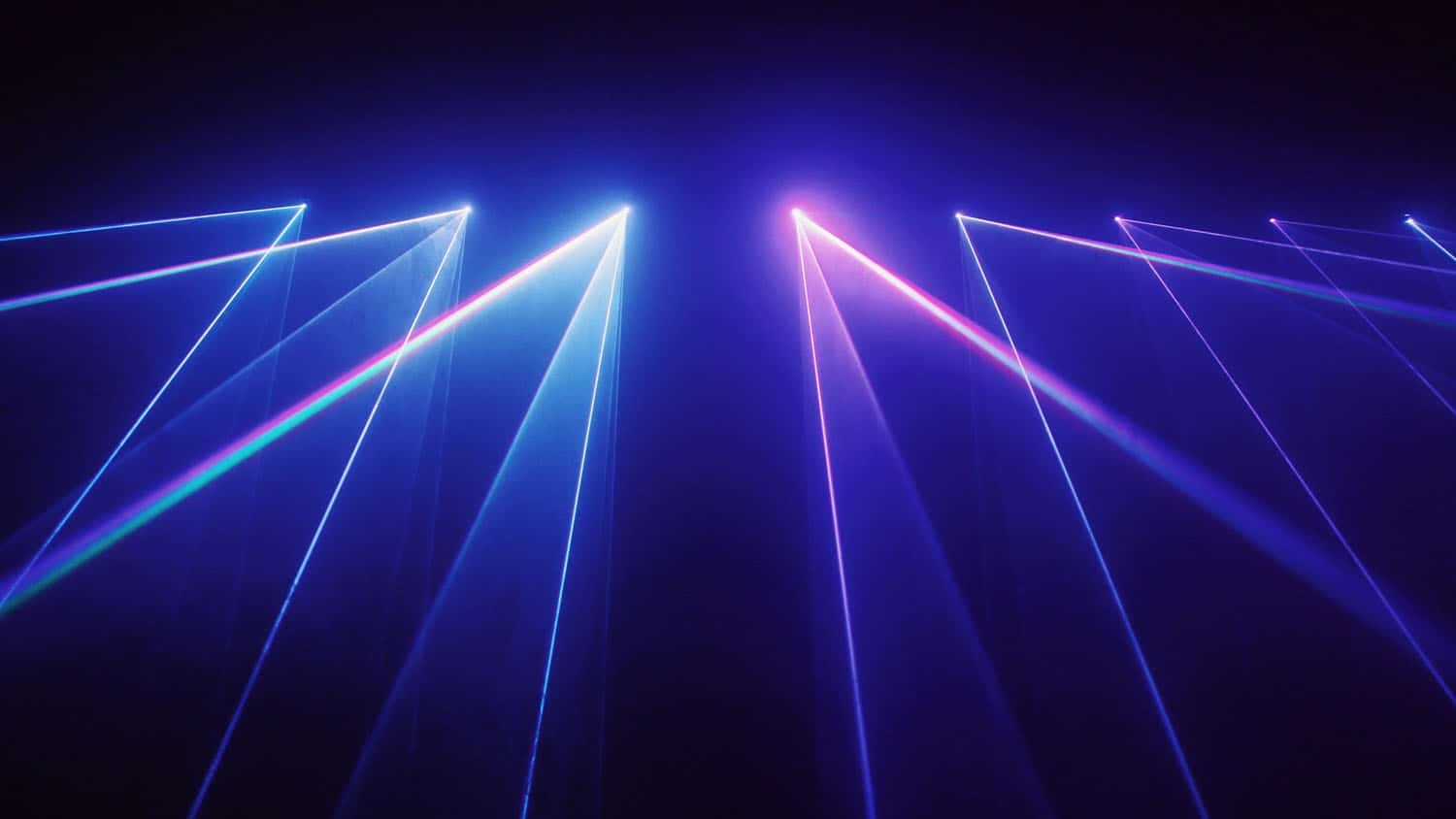 laser lights in blue and purple shine at angles in front of a black background