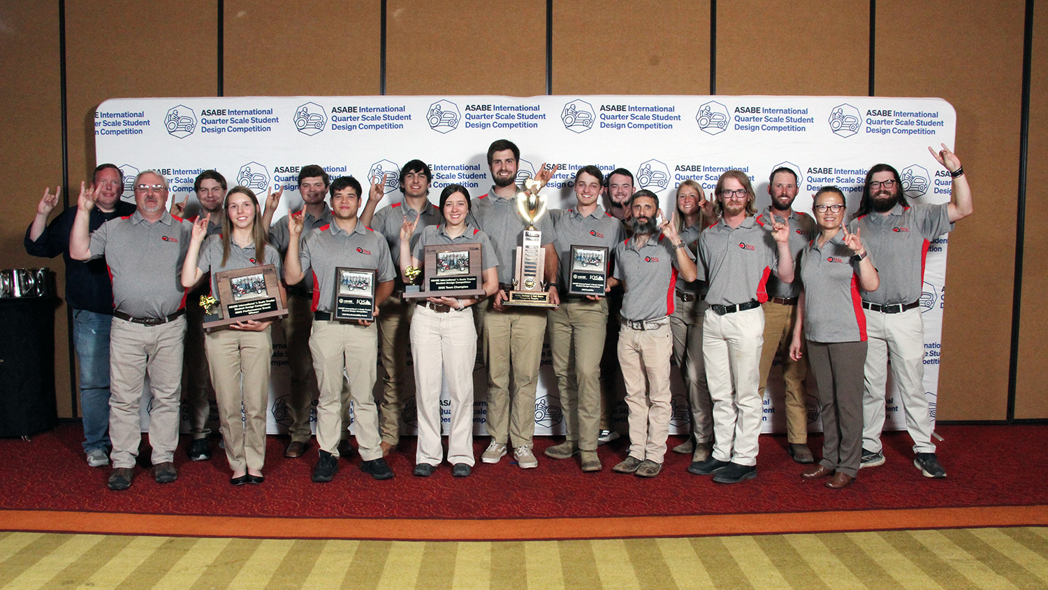a group of people post with trophies making wolfy ears with their hands