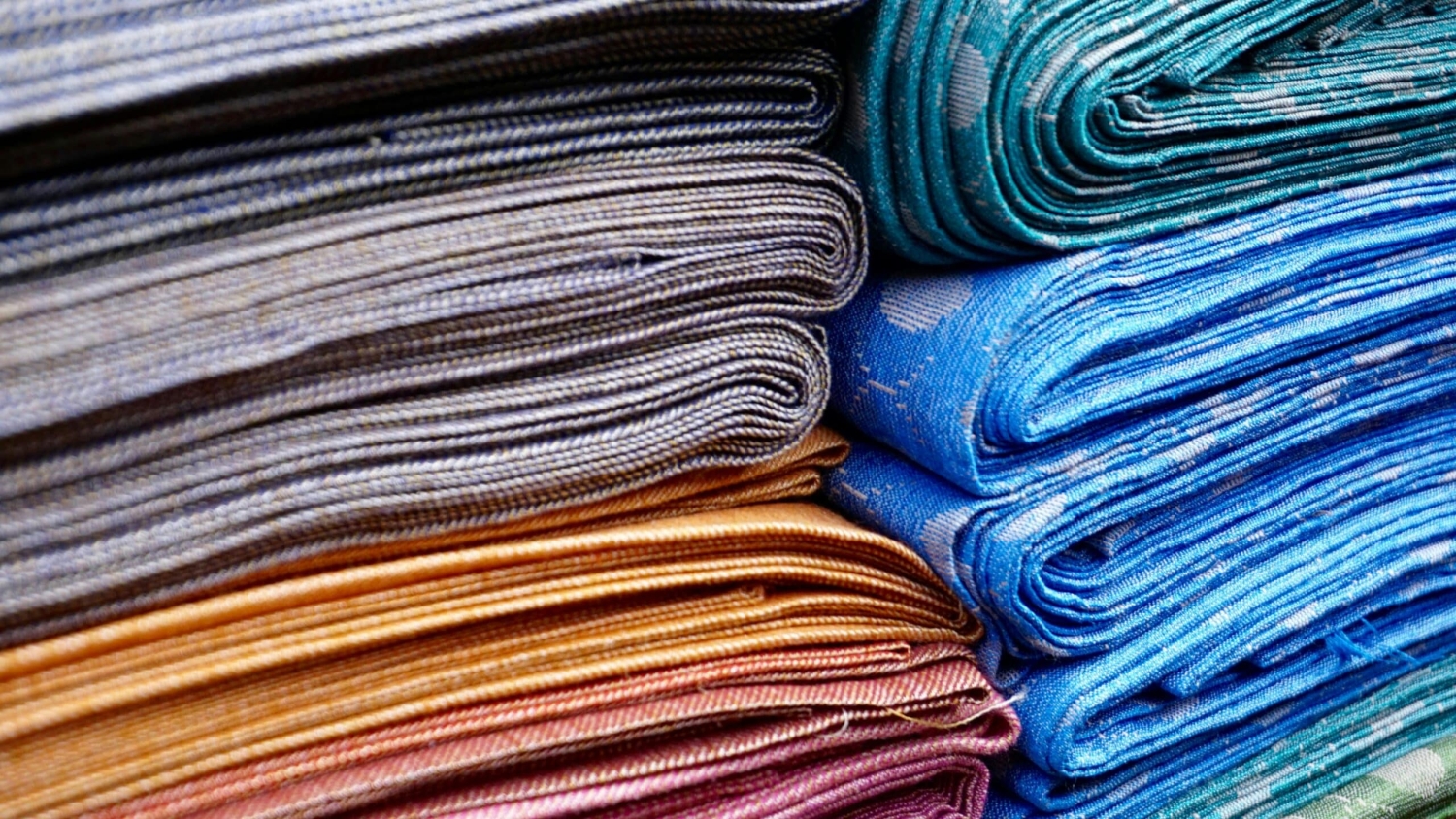 photo shows two stacks of different colors of towels seen from their edges