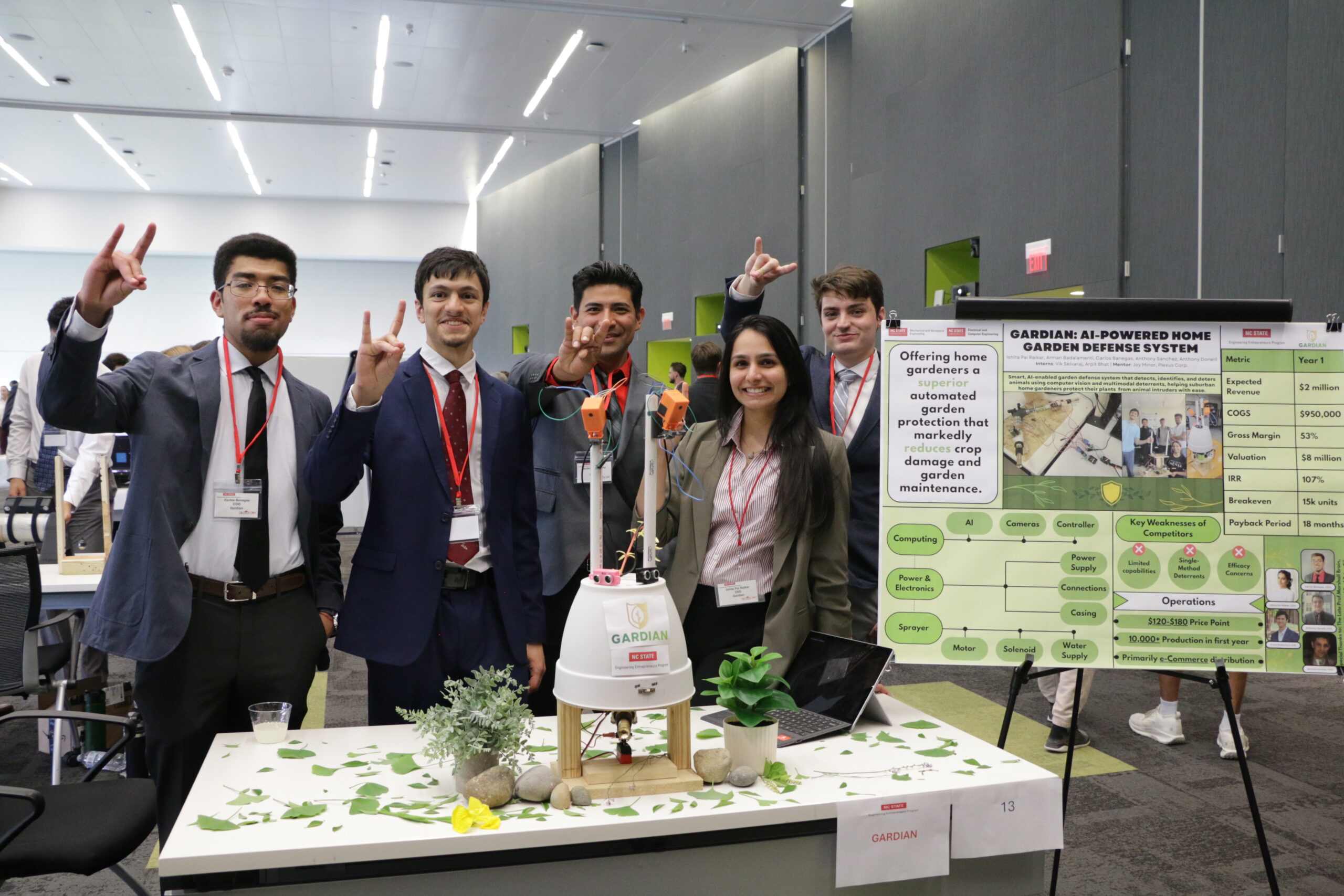 a group of EEP students pose for a group photo while standing behind a table and poster displaying their project