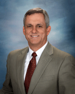 older man wearing a light brown suit