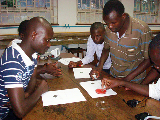 Students in Africa work with an experiment kit from SciBridge.