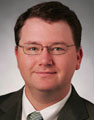 man wearing glasses and a dark suit