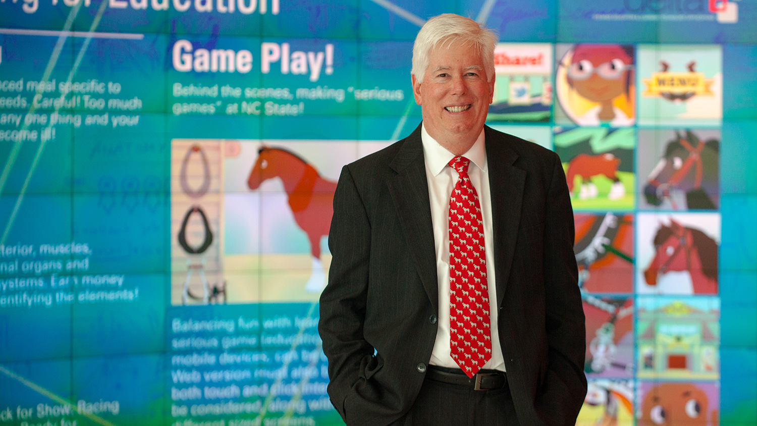 Tom Miller standing in front of digital wall display.