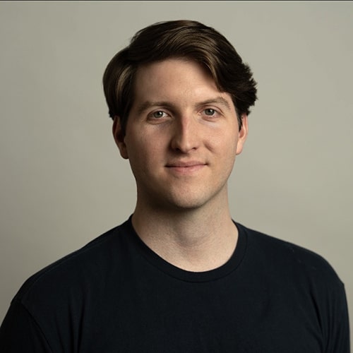 man with dark hair wearing a black crew neck shirt